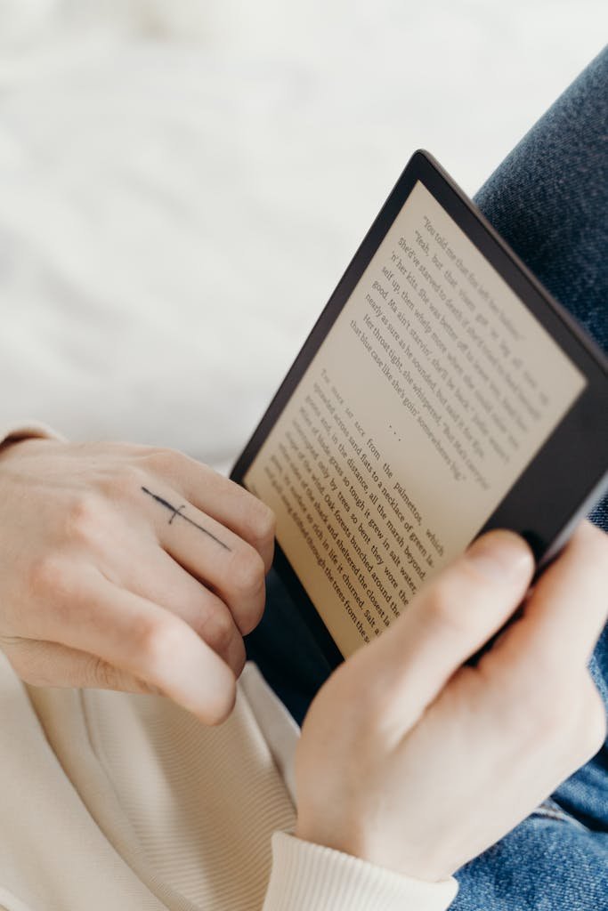 Detailed view of hands reading an e-book on an electronic device.